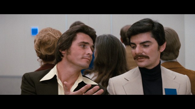 A scene featuring a man dressed as a cardinal, standing in front of a building with signs related to Catholicism.