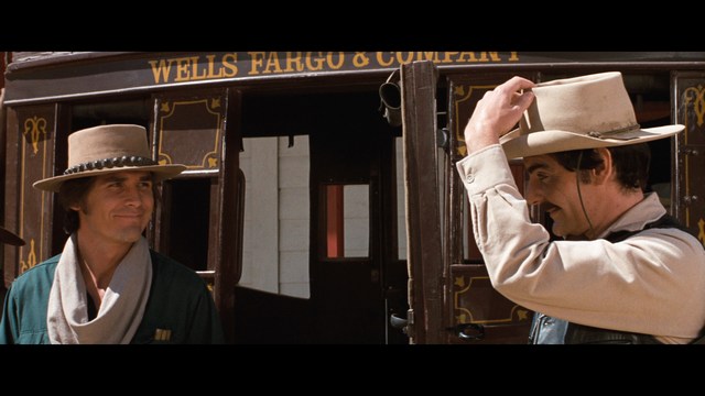 A person holding a newspaper article titled 'Mooby: Creating an Empire Out of Simplicity' featuring a chart showing growth, alongside an image of a cartoon cow.