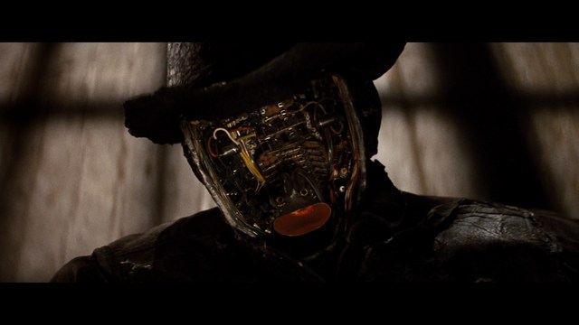 A scene featuring a man sitting with his arms crossed, looking away, and a woman with a concerned expression, seen in a dimly lit bar setting.