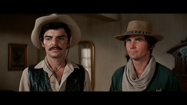 A group of people standing in a church, with a focus on a woman in a striped blazer looking up, while others are holding books or looking ahead.