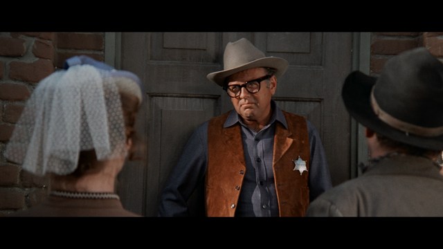 Three characters looking down with surprised expressions, framed from below.