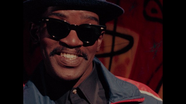 A close-up of a person's hand holding a crumpled newspaper with the headline "Mooby's: Creating an Empire Out of Simplicity" and a graphical chart showcasing growth, titled "It was a very Good YEAR."