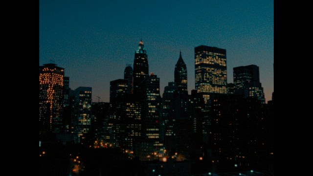 Two men are engaged in conversation at a colorful playground with bright slides in the background.