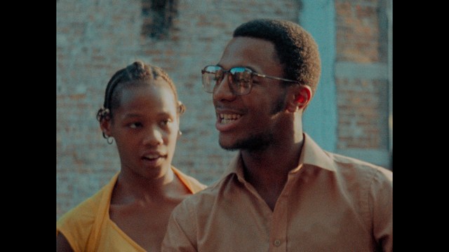 Two characters wearing red bandanas look surprised while standing in a dimly lit indoor setting.